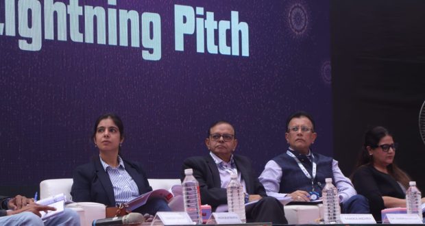 Panel of judges seated on stage during the Lightning Pitch session at a startup event