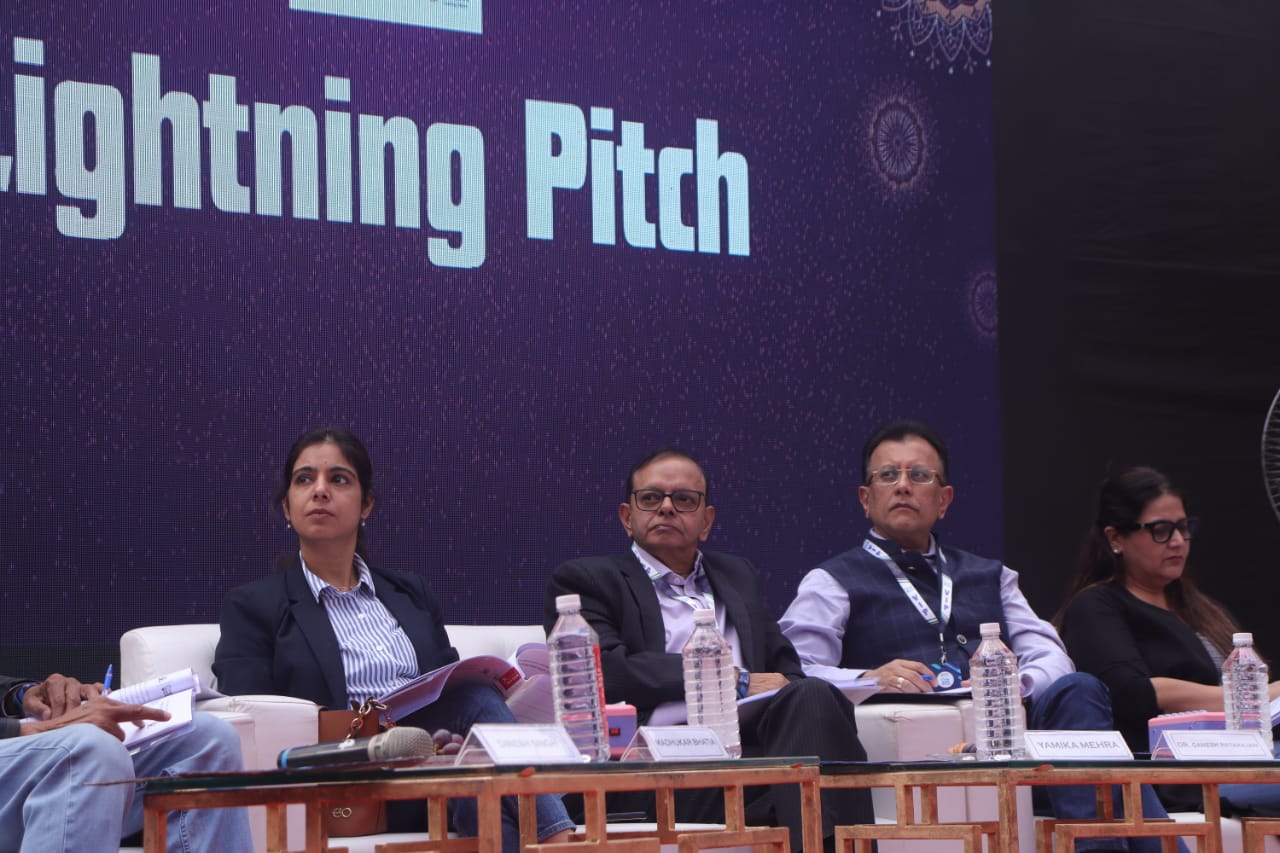 Panel of judges seated on stage during the Lightning Pitch session at a startup event
